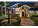 Elegant home exterior featuring brick accents, an arched entryway, and a tranquil fountain at 2614 W Ponkan Rd, Apopka, FL 32712