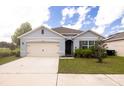 Inviting single-Gathering home boasting a tidy lawn, a two-car garage, and a welcoming entrance under a blue sky at 3332 Logan Berry Dr, Mount Dora, FL 32757