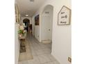 Inviting hallway featuring tile floors, arched doorways, and decorative accents, creating a warm atmosphere at 3332 Logan Berry Dr, Mount Dora, FL 32757