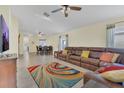 Spacious living room featuring tile flooring, a ceiling fan, and a comfortable leather sectional at 340 Grand Canal Dr, Poinciana, FL 34759