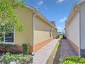 Exterior showing a brick-paved walkway between neighboring properties, with lush landscaping and a clear blue sky at 3640 Solana Cir # A, Clermont, FL 34711