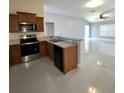 A modern kitchen featuring stainless steel appliances, wood cabinets, and tile flooring at 3719 Madbury Cir, Lakeland, FL 33810