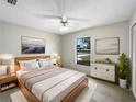 Bright bedroom featuring a ceiling fan, contemporary decor, and a large window offering natural light at 832 Yellowbird Ave, Deltona, FL 32725