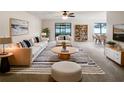 Bright living room with neutral furniture, striped rug, and open floor plan to dining area at 832 Yellowbird Ave, Deltona, FL 32725