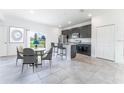 Stylish kitchen and dining area featuring granite countertops, modern appliances, and a sliding glass door to the backyard at 13220 Sw 85Th Pl, Ocala, FL 34473