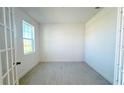 Well-lit home office featuring neutral paint, tile floors, a large window, and glass panel French doors at 14575 Crestavista Ave, Clermont, FL 34714