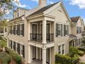 Well-maintained townhome featuring a covered porch, balcony, black shutters, and manicured landscaping at 1531 Lake Baldwin Ln, Orlando, FL 32814