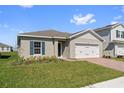 Single-story home boasting a well-manicured lawn and brick driveway at 1630 Laia Rd, Haines City, FL 33844