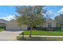 Inviting single-story home with manicured lawn, mature trees, and a welcoming entrance at 1657 Cherry Ridge Dr, Lake Mary, FL 32746