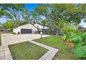 Fenced backyard with a large driveway and lush green lawn at 1804 Wind Willow Rd, Belle Isle, FL 32809