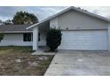 A well-maintained single-story home with attached garage, a welcoming front porch, and tidy landscaping at 1845 Portview Ave, Deltona, FL 32738