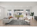 Bright living room features light wood floors, neutral furniture, and sliding glass doors to the backyard at 19307 Banfield Pl, Orlando, FL 32827