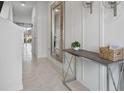 Bright foyer features a large mirror, console table and tile flooring leading into the home at 2152 Monteverde Ave, Davenport, FL 33896