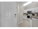 Entryway view of kitchen with white cabinets and stainless steel appliances at 3133 Yellow Lantana Ln, Kissimmee, FL 34747