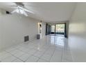 Bright living room featuring tile flooring and a ceiling fan, leading to a screened lanai at 3467 Flossmoor Ave # 101, Orlando, FL 32822