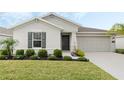 Beautifully landscaped front yard of a single-story home with dark shutters and a gray facade at 3920 Guernsey Bnd, St Cloud, FL 34772