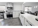 Bright, modern kitchen with stainless steel appliances, black countertops, and stylish backsplash at 417 Evesham Pl, Longwood, FL 32779