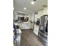 Bright kitchen featuring white cabinetry, stainless steel appliances, and breakfast bar at 417 Evesham Pl, Longwood, FL 32779