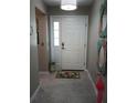 Inviting foyer with tile flooring, a flamingo accent, and a bright white front door at 419 Aldama Ave, Lady Lake, FL 32159