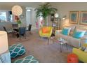 Bright living room featuring modern decor, including a decorative palm tree and colorful throw pillows at 419 Aldama Ave, Lady Lake, FL 32159