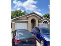 Inviting single-story home featuring an attached garage, manicured lawn and a welcoming entrance at 4954 Luna Negra Dr, Orlando, FL 32811