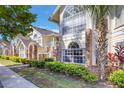 Condo exterior featuring large windows, palm tree, and manicured landscaping at 5007 Laguna Bay Cir # 31, Kissimmee, FL 34746