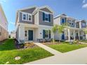 Charming two-story home with gray shingles, teal shutters, manicured lawn, and walkway at 6140 Shavasana Rd, Clermont, FL 34714