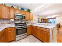 Well-lit kitchen with wooden cabinets, stainless steel appliances and a breakfast bar at 7978 Se 174Th Belhaven Loop, The Villages, FL 32162