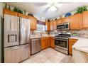 Efficient kitchen features stainless steel appliances, wood cabinets, and tiled backsplash at 7978 Se 174Th Belhaven Loop, The Villages, FL 32162