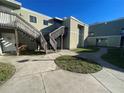 Exterior angle of an apartment building showing the lawn and stairs leading up to the second story door at 101 Scottsdale Sq # 101, Winter Park, FL 32792