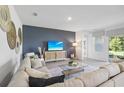 Inviting living room showcasing a comfortable sectional, decorative wall art, and a sleek TV console at 1507 Fountain View St, Ormond Beach, FL 32174