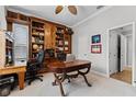 Home office showcasing custom built-in bookshelves, a classic desk, and neutral carpet flooring at 1613 Glenwick Dr, Windermere, FL 34786