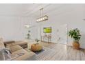 Bright living room with stylish decor, wood flooring, modern lighting, and a comfortable sectional sofa at 1832 Magnolia Ave, Winter Park, FL 32789