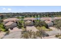 An aerial view showcases homes with tile roofs on a cul-de-sac near a scenic lake at 2020 Imperial Eagle Pl, Kissimmee, FL 34746