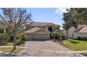 Elegant two-story home featuring a three-car garage, tile roof, and paver driveway at 2020 Imperial Eagle Pl, Kissimmee, FL 34746