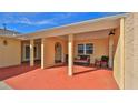 Inviting front porch featuring comfortable seating, decorative pillars, and a red painted patio at 209 Georgetowne Blvd, Daytona Beach, FL 32119