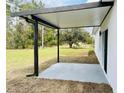 A covered patio with a neutral concrete floor offers an extension of the living space and a serene backyard view at 2549 Sw 163Rd Pl, Ocala, FL 34473