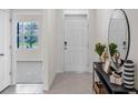 Welcoming foyer featuring a white front door, a stylish console table with decorative elements, and tile flooring at 2817 Jamaica Way, Haines City, FL 33844