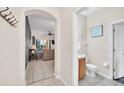 Hallway with views of the living room, tiled floors, and a conveniently located half-bath at 438 Miramar Ave, Davenport, FL 33897