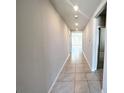Long hallway with neutral paint, tile floors, and recessed lighting at 464 Patricia Alford Dr, Haines City, FL 33844