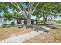 Beautiful single-story home with mature landscaping creating a serene setting and a well-kept lawn at 5202 Greenway Drive, Orlando, FL 32819