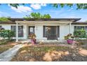 Charming home with a cozy front porch, complete with decorative plants and a quaint bench at 5202 Greenway Drive, Orlando, FL 32819