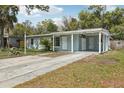 Exterior of a light blue house with a spacious driveway and covered carport at 5215 Ashwood Pl, Orlando, FL 32808