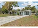 Spacious front yard with a carport featuring a light blue exterior at 5215 Ashwood Pl, Orlando, FL 32808