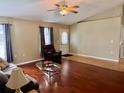 Bright living room with hardwood floors, ceiling fan, and comfortable seating arrangement at 5347 Pecan Rd, Ocala, FL 34472