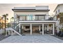 Modern two-story home featuring a beautiful outdoor kitchen, patio, and balcony, perfect for entertaining at 6480 S Atlantic Ave, New Smyrna Beach, FL 32169