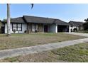 Single-story house featuring a two-car garage, stone accents, and a neatly kept lawn on a sunny day at 7508 Covedale Dr, Orlando, FL 32818