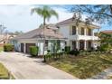 Elegant exterior view of a home with a three-car garage, tile roof, and manicured landscaping at 8661 Crestgate Cir, Orlando, FL 32819