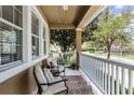 Cozy front porch featuring comfortable seating, decorative rug, white railings, and a view of the manicured community at 9228 Cardinal Meadow Trl, Orlando, FL 32827