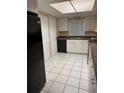 A kitchen with white cabinets, tile floors, and a black refrigerator and dishwasher at 9916 Sweepstakes Ln # 1, Orlando, FL 32837